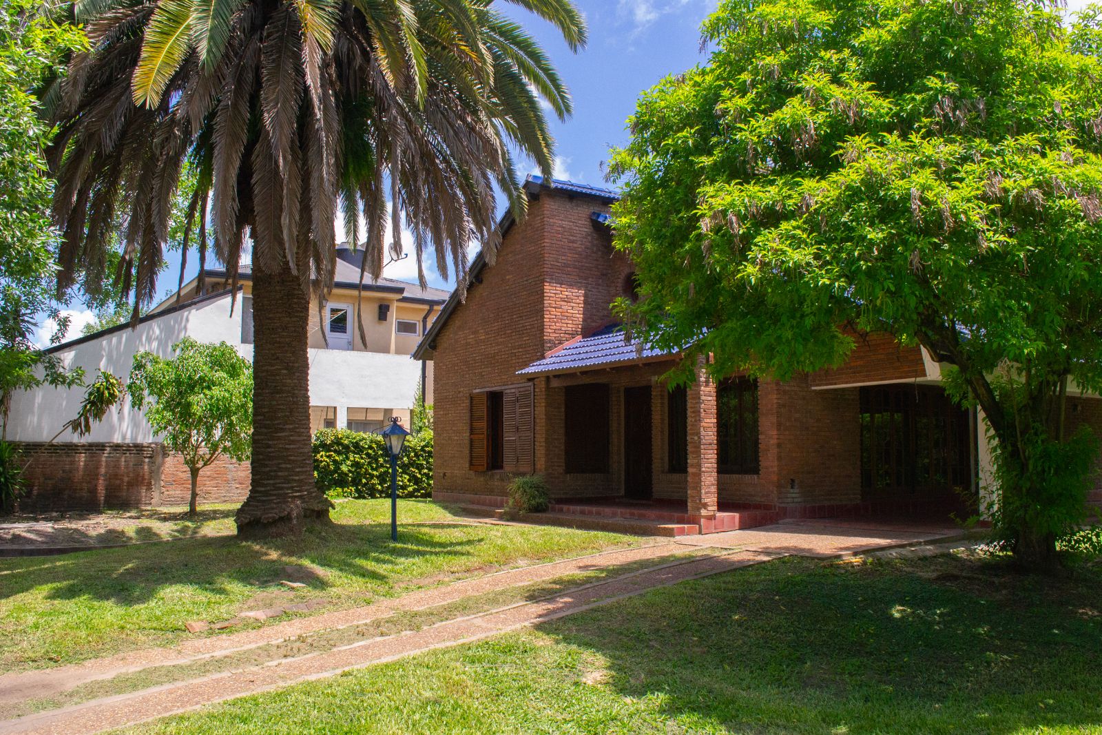 Frente del chalet de ladrillo con palmera y parque, zona centro de San José